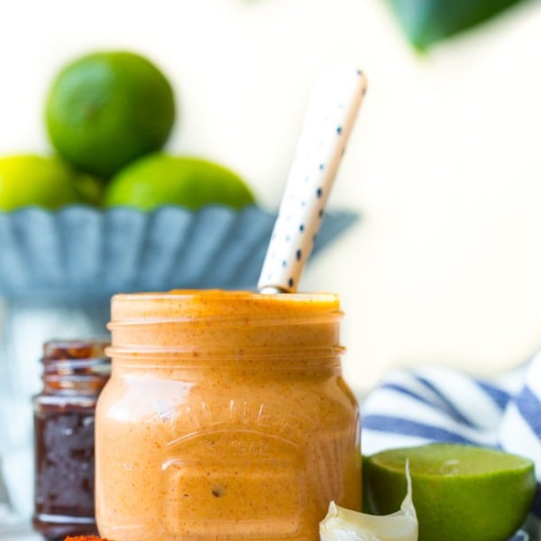 jar of chipotle mayo on a plate with garlic, lime and spices