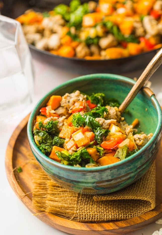 Sausage Kale Sweet Potato Hash in a green bowl with a fork