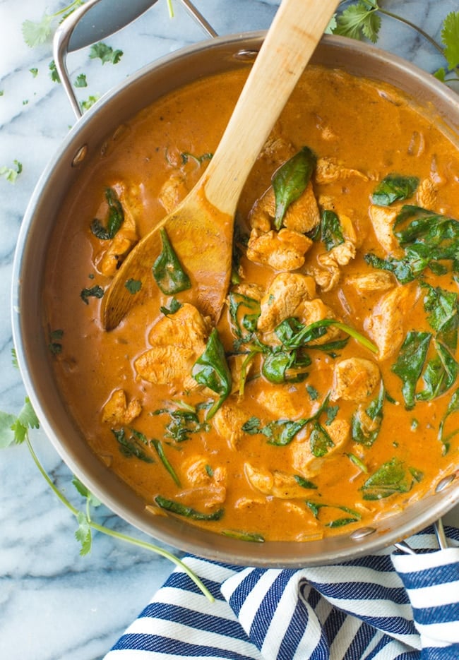 Tomato Coconut Curry Chicken in a skillet on a marble surface