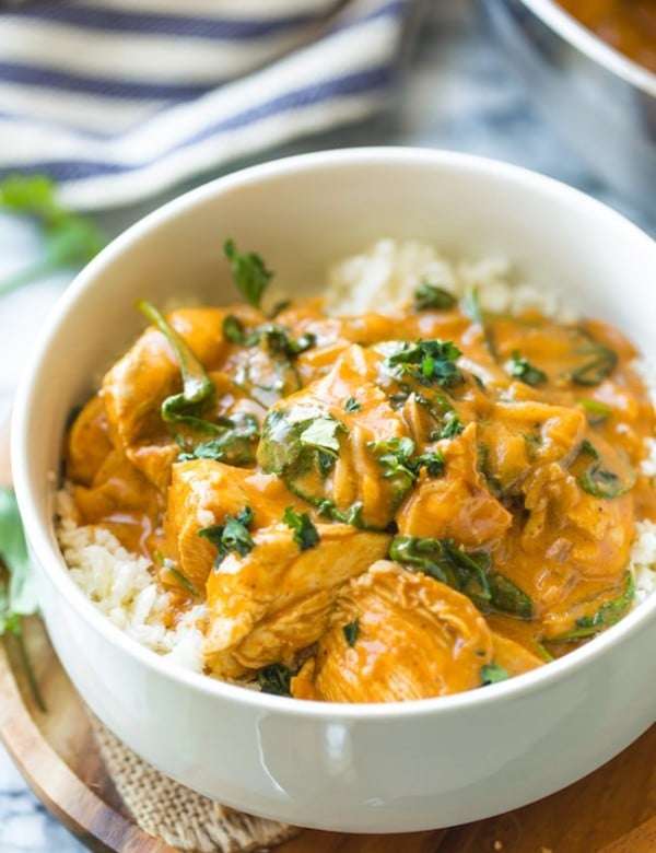 Tomato Coconut Curry Chicken in a white bowl topped with cilantro