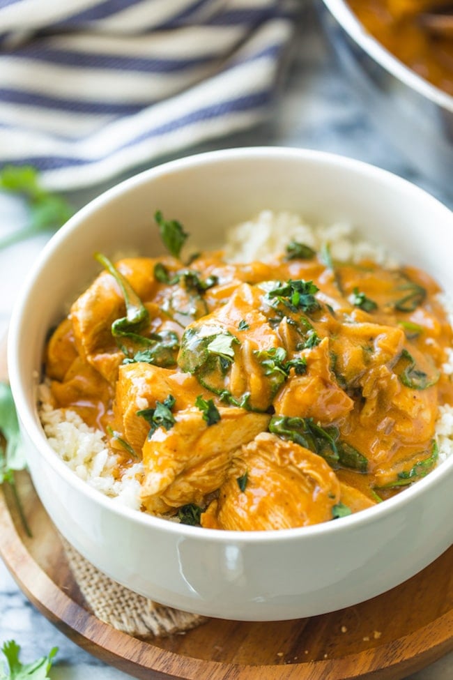 Tomato Coconut Curry Chicken in a white bowl topped with cilantro