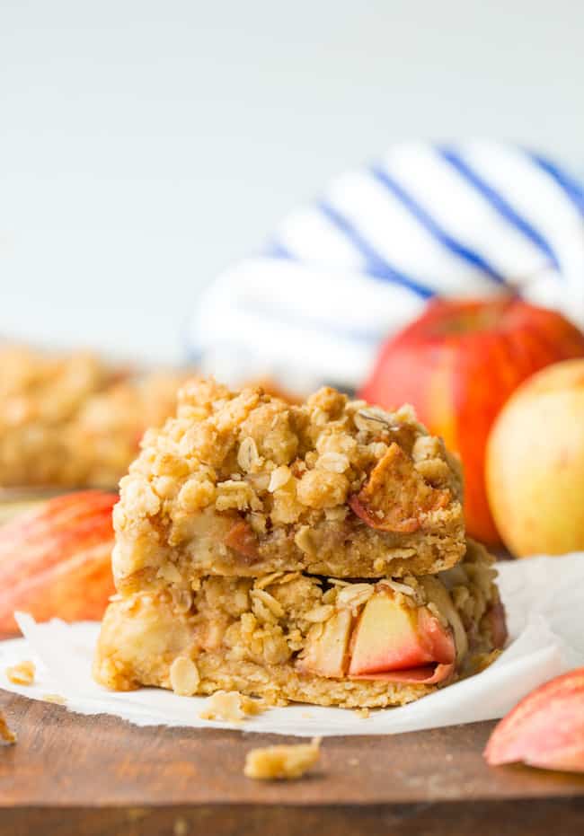 two apple crumble bars on a wooden cutting board