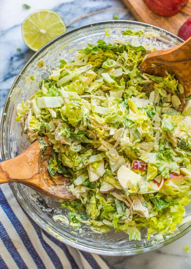 paleo chicken salad mixed together in a salad bowl with wooden tongs