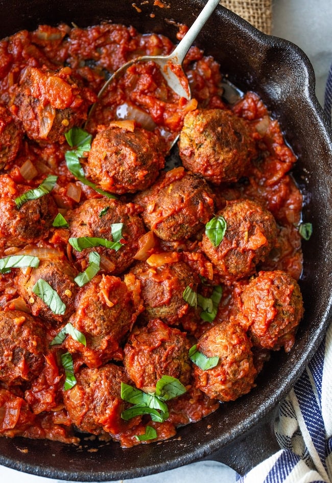 Vegan Lentil Meatballs up close in a cast iron skillet in marinara