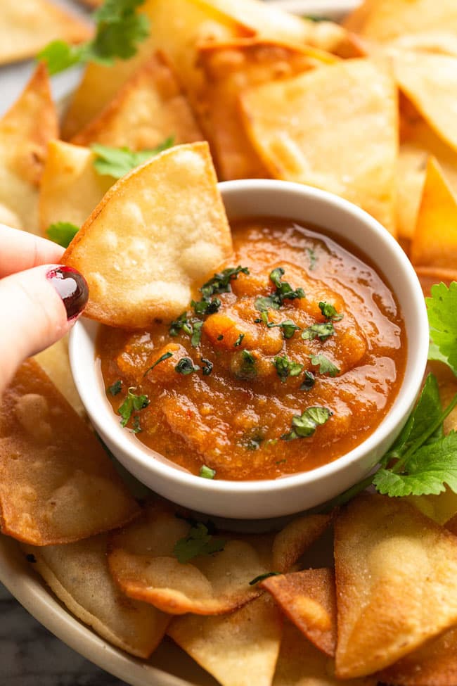 Roasted Chipotle Salsa with a chip dipping in the salsa