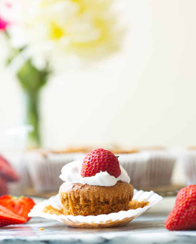 Paleo Vegan Cupcakes with whipped cream and a strawberry on top