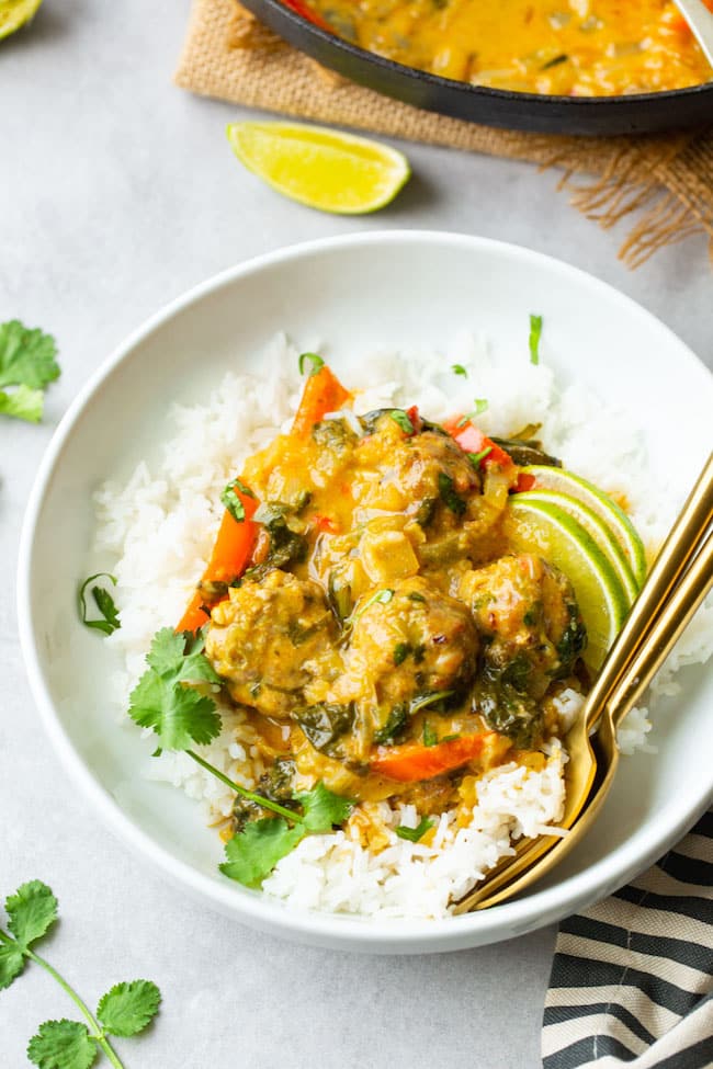 Chicken-Meatball-Coconut-Curry in a serving bowl with a fork and spoon
