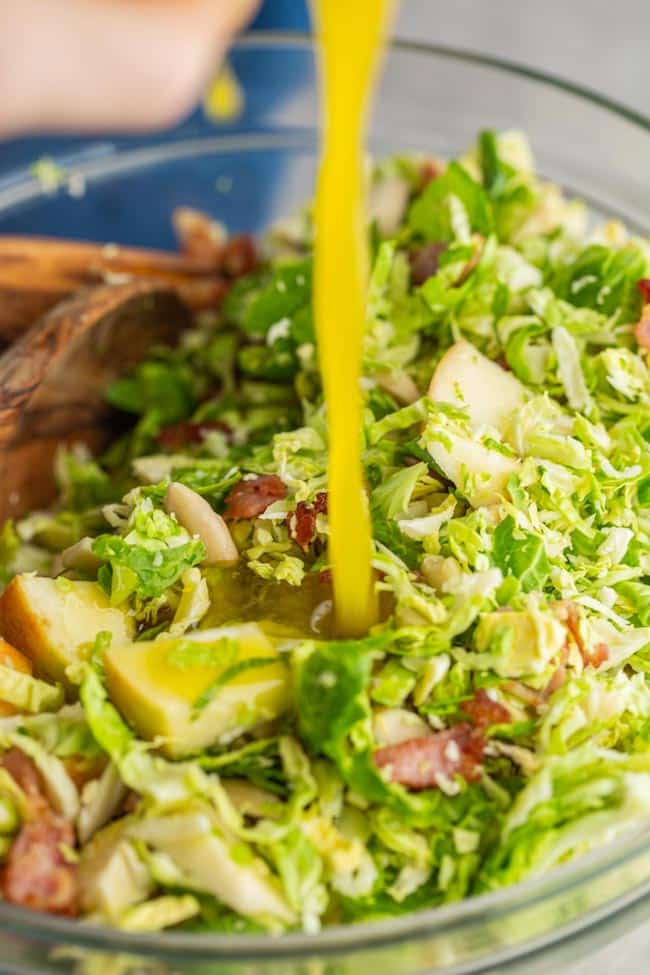  Honey Mustard Vinaigrette  pouring over Shaved Brussels Sprouts Salad with Apples