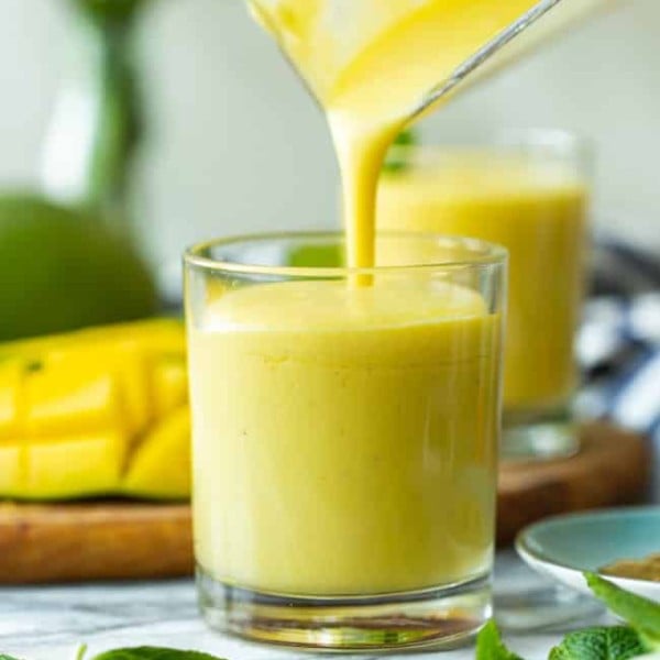 mango lassi pouring into a cup