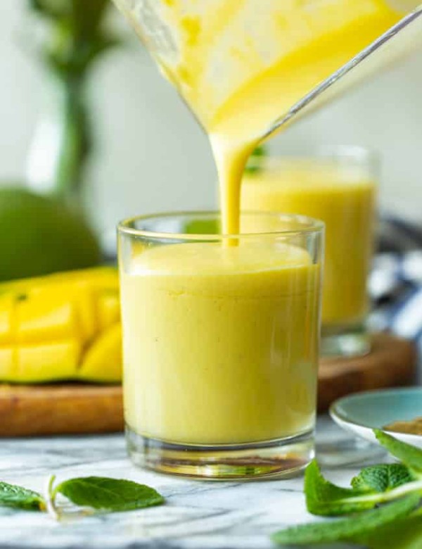 mango lassi pouring into a cup