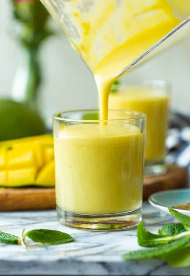 mango lassi pouring into a cup