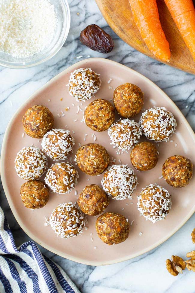 Carrot Cake Bliss Balls on a plate, some rolled in coconut 