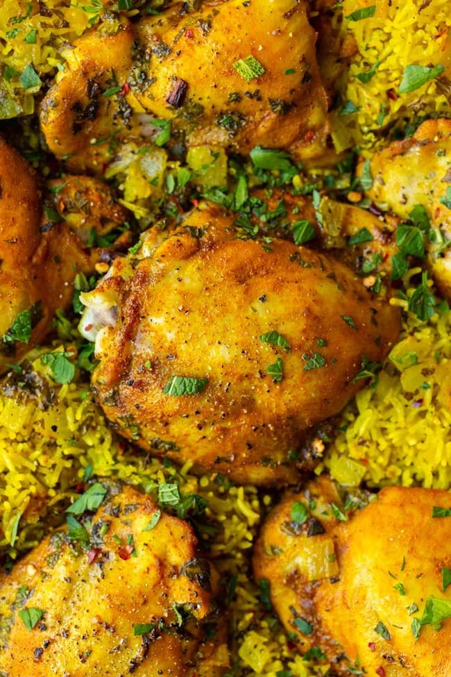 Herby Golden Baked Chicken and Rice up close topped with topped herbs