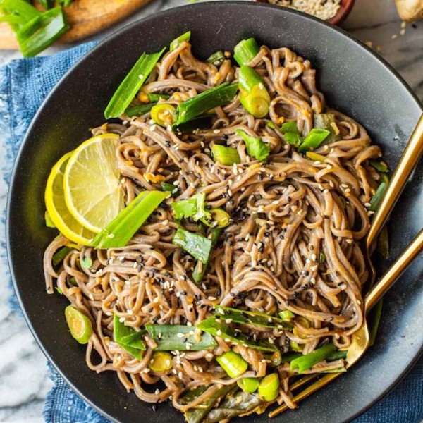 Spring Onion Peanut Noodles in a black bowl