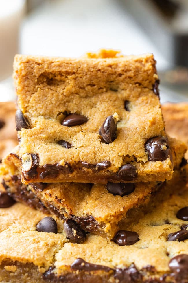 almond flour cookie bars on a marble surface surrounded by chocolate chips