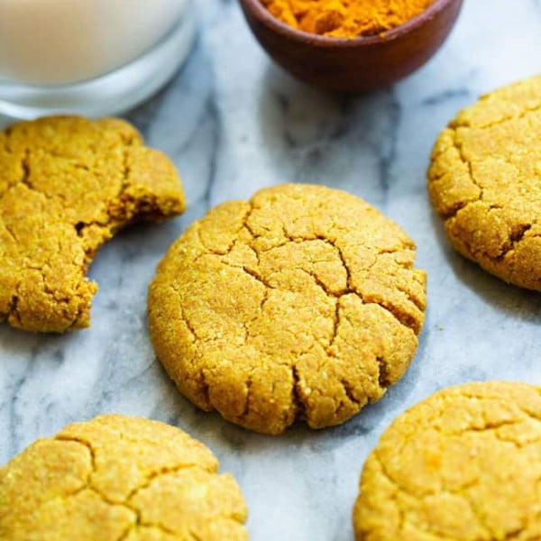 Golden Almond Cookies on a marble counter with powered turmeric