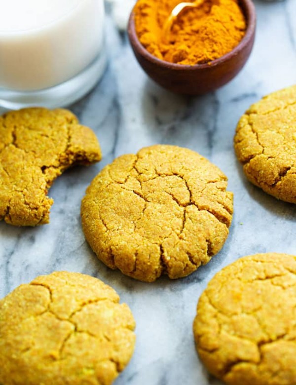 Golden Almond Cookies on a marble counter with powered turmeric