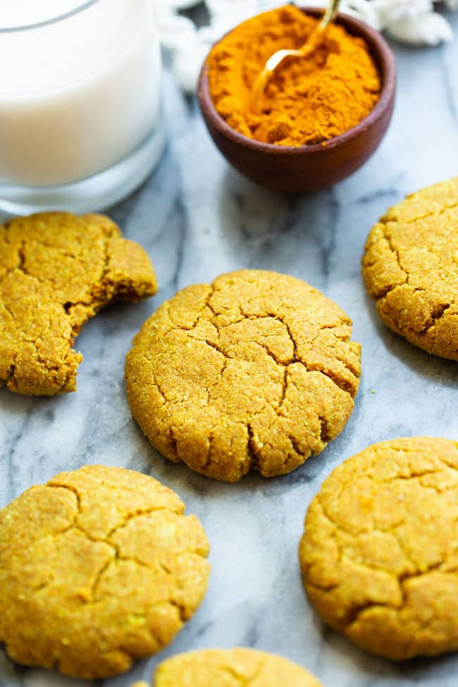 Golden Almond Cookies on a marble counter with powered turmeric