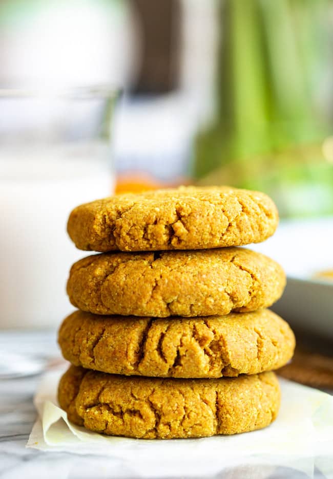 stack of Golden Almond Cookies on a marble counter with powered turmeric