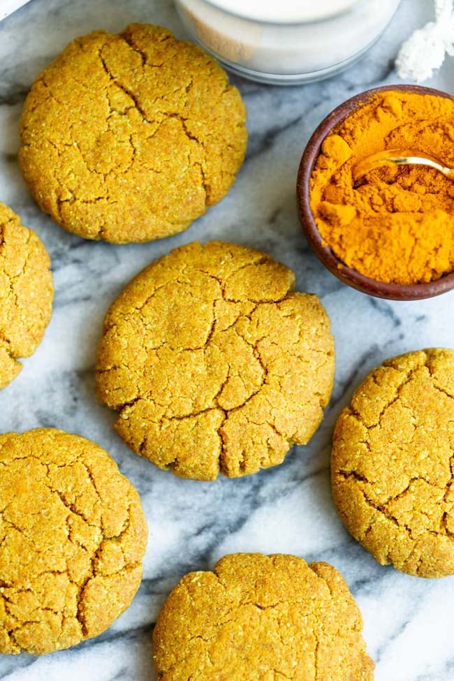 Golden Almond Cookies on a marble counter with powered turmeric