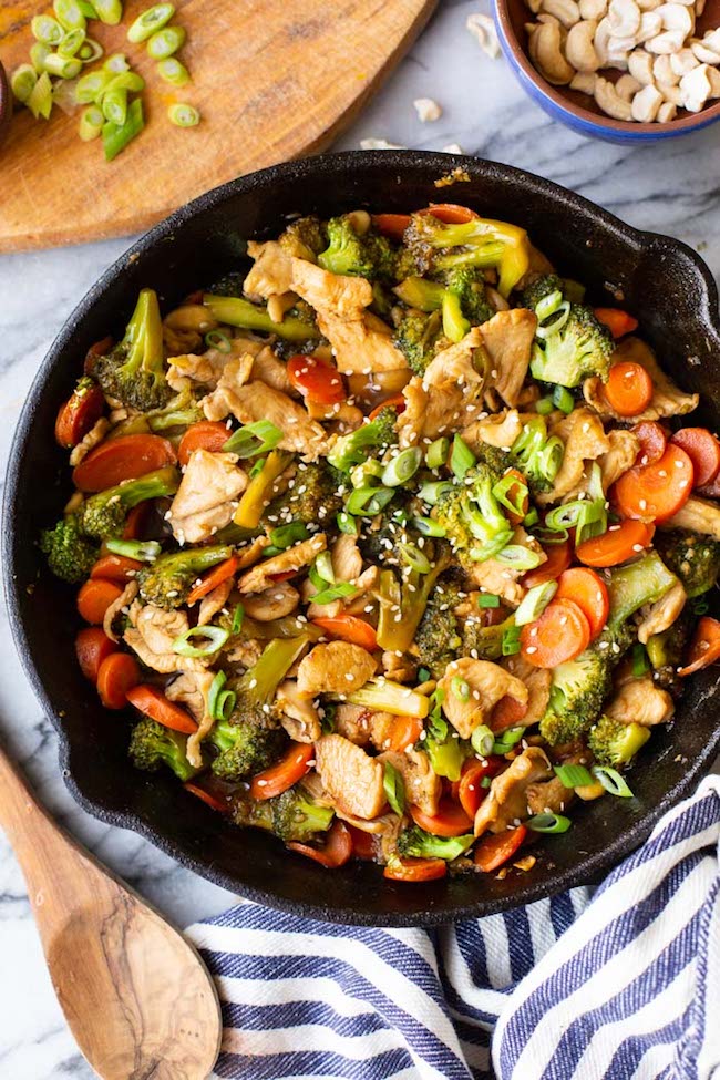 Teriyaki Kycklingbroccoli rör stek i en gjutjärnspanna på en marmoryta