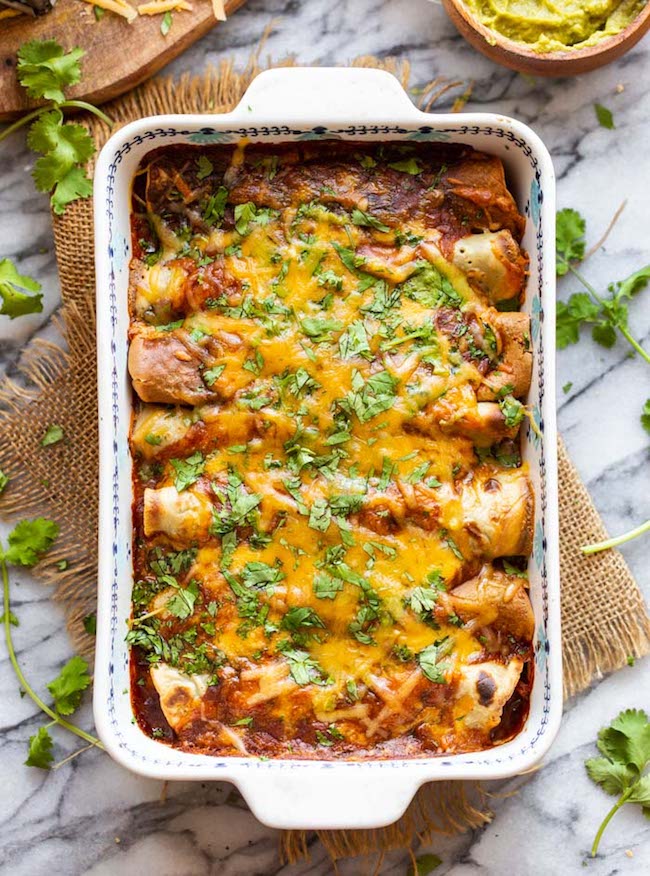 gluten free enchiladas in a casserole dish topped with cheese and cilantro