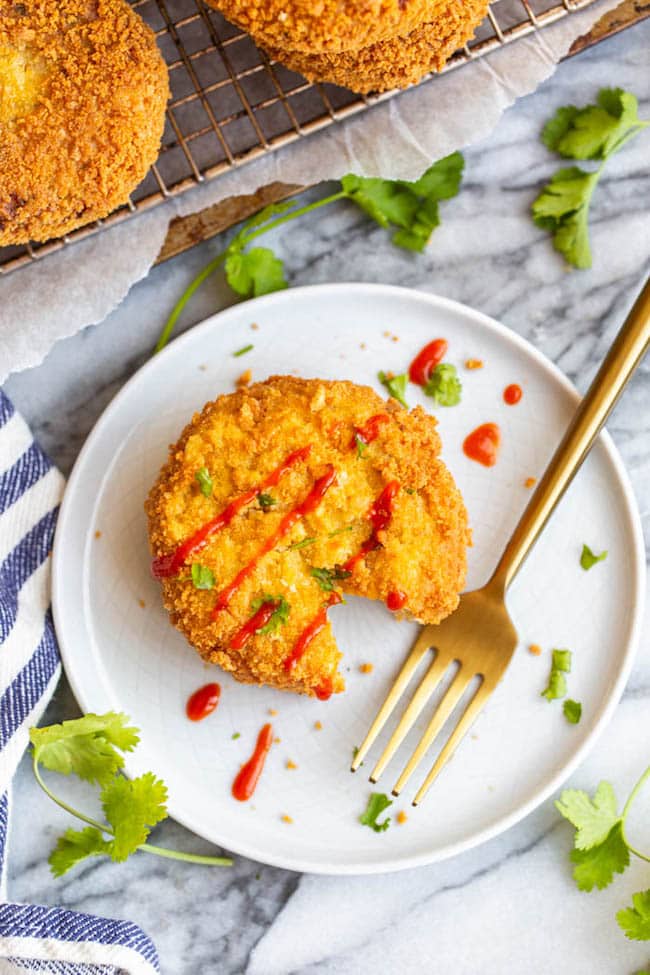 Gluten Free Salmon Cakes on a small plate drizzled with sriracha 