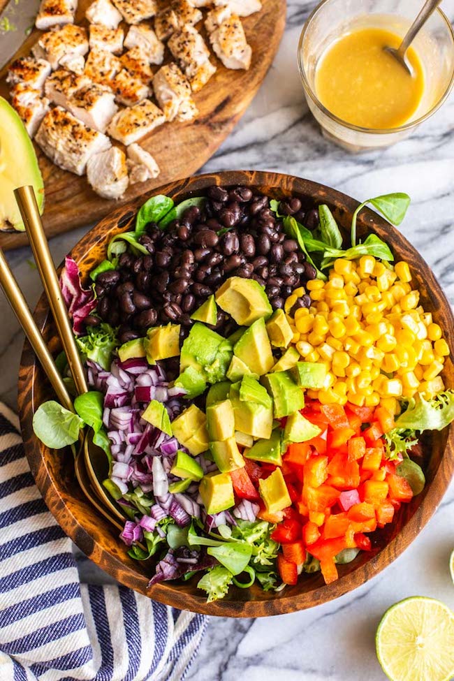 unmixed southwest chicken salad in a salad bowl with serving spoons