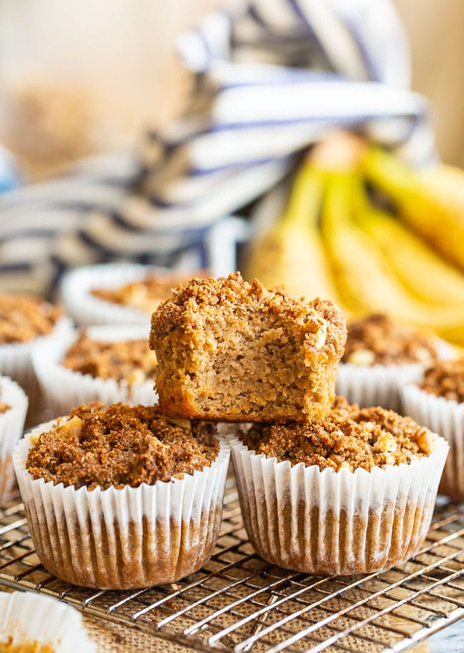 one Paleo Banana Crumb Muffins stacked on top of two others with a bite taken out