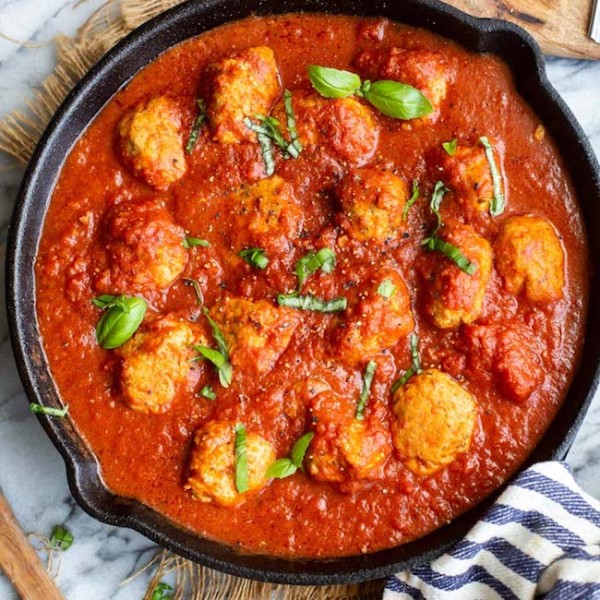 chicken meatballs in marinara sauce in a cast iron skillet