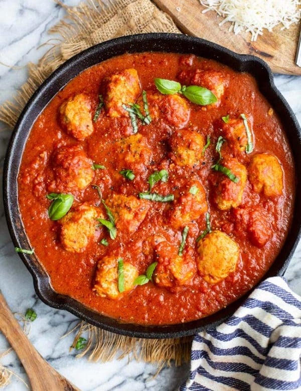 chicken meatballs in marinara sauce in a cast iron skillet