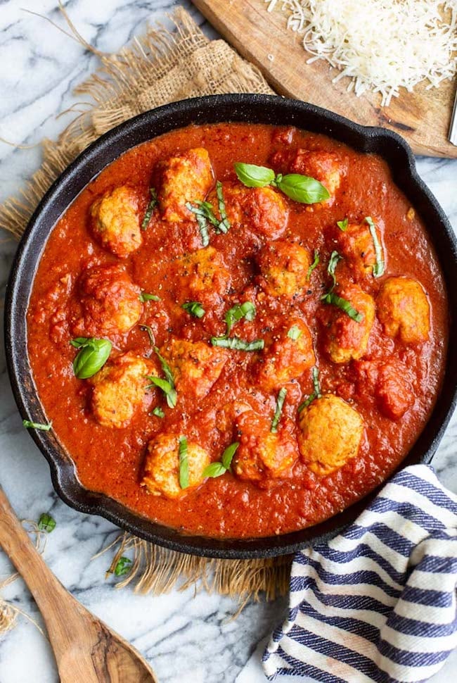 Healthy Chicken Meatballs in a cast iron skillet with basil