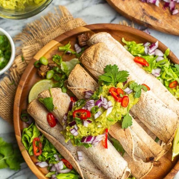 Jackfruit Carnitas Taquitos topped with guacamole and chilies