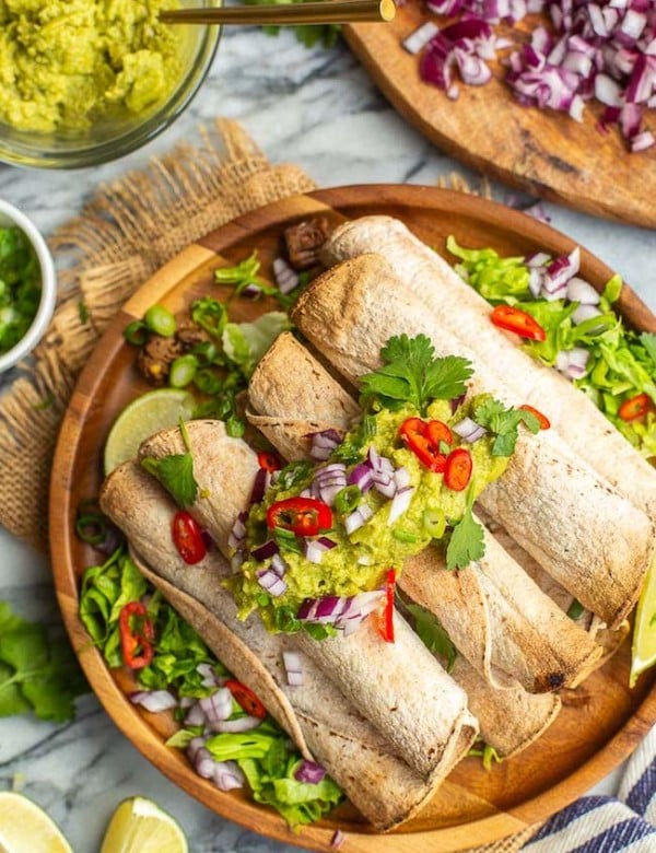 Jackfruit Carnitas Taquitos topped with guacamole and chilies