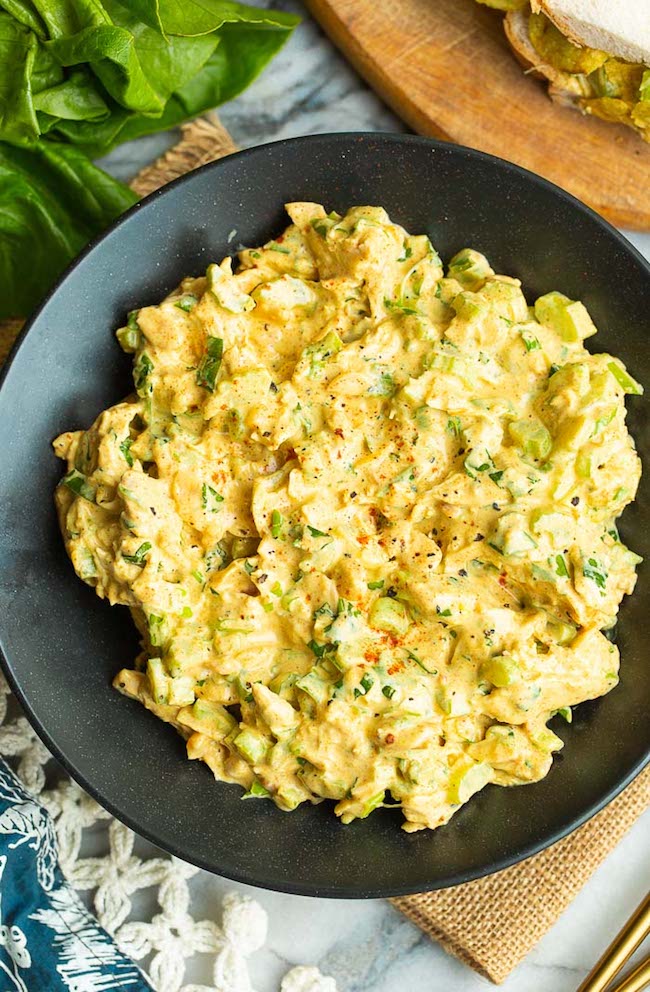 Coronation Chicken in a black bowl topped with freshly chopped cilantro