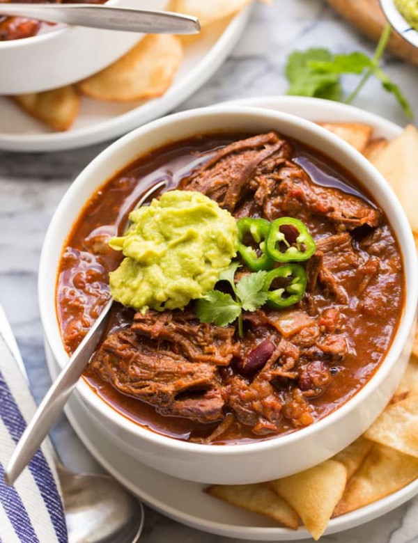 Instant-Pot-Chili-Con-Carne-with-Shredded-Beef in a white bowl topped with guacamole