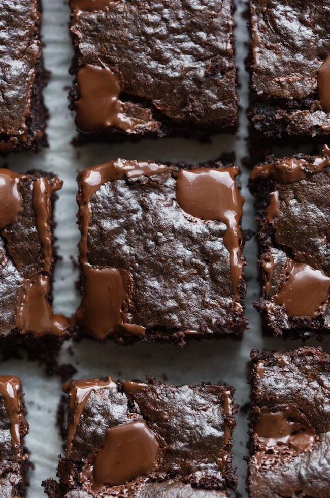 vegan Zucchini Brownies cut into squares with melted chocolate