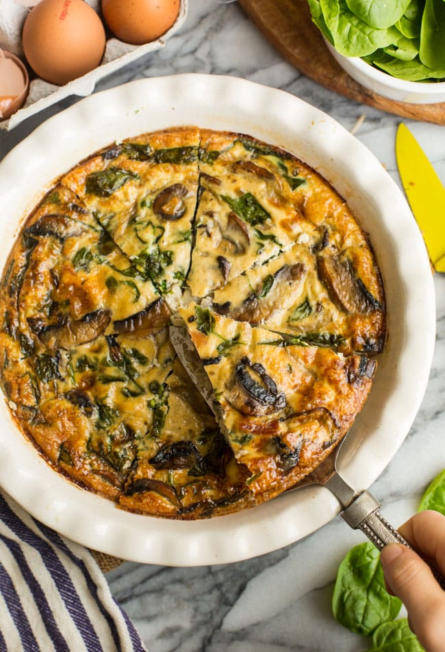 serving spoon holding up a Bacon & Mushroom Crustless Quiche  