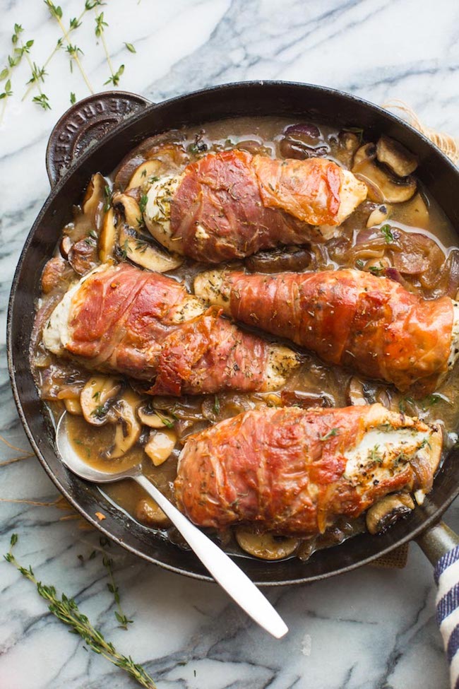 Prosciutto Wrapped Chicken with Mushrooms in a cast iron skillet with thyme