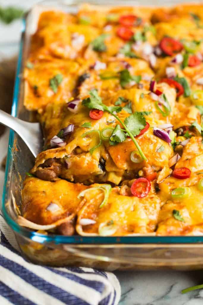 spatula picking up a slice of Black Bean & Butternut Squash Enchilada Casserole