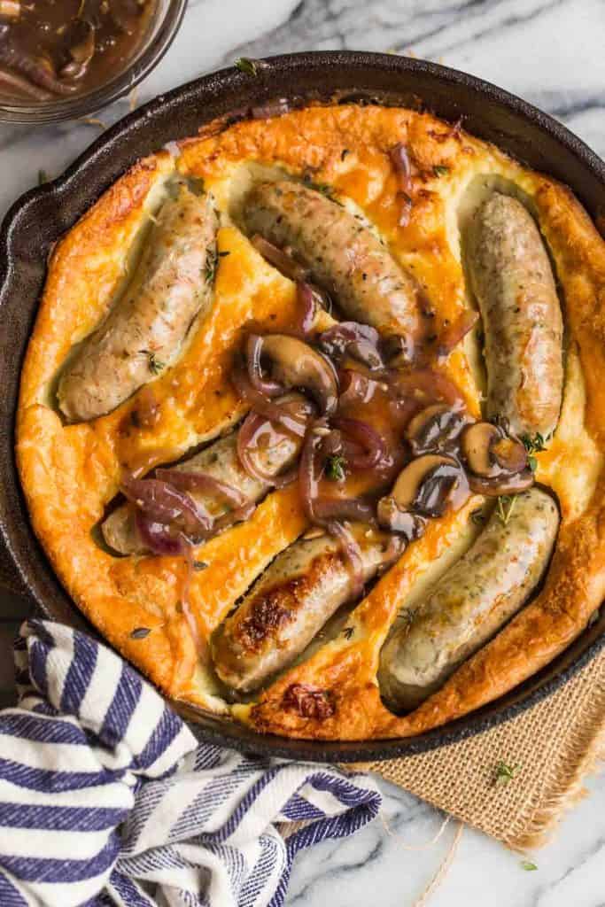 paleo toad in the hole in a cast iron skillet and covered in a mushroom onion gravy