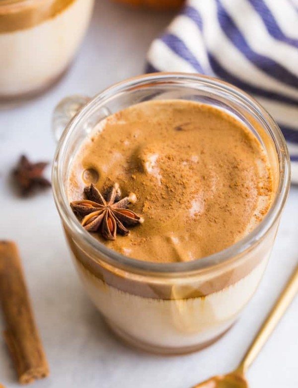 pumpkin spice dalgona topped with star anise in a glass mug