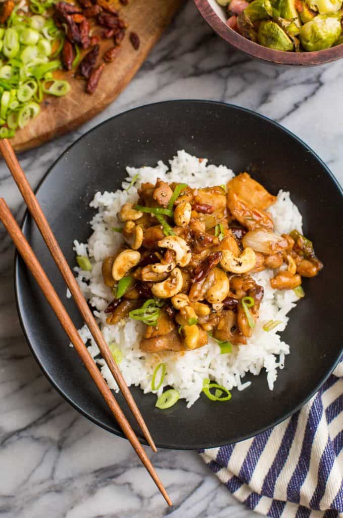 Spicy Cashew Chicken in a black bowl with chopsticks