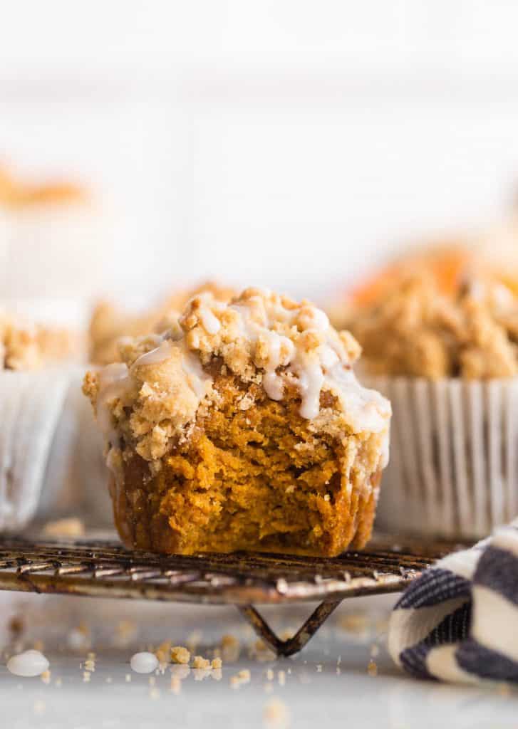 Pumpkin & Gingerbread Crumb Muffins with icing on a cooling rack