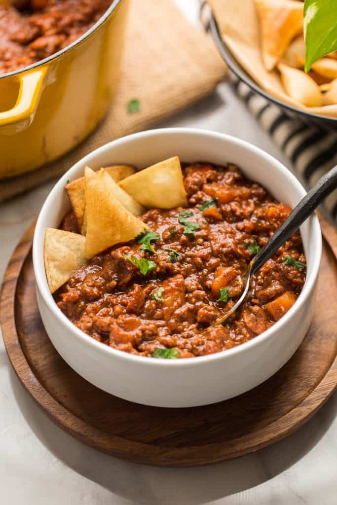 Smokey Sweet Potato Chocolate Chili in a white bowl with tortilla chips