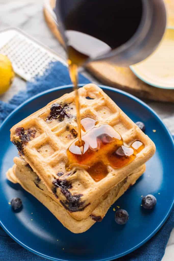 Gluten Free Blueberry Waffles with syrup pouring over the top