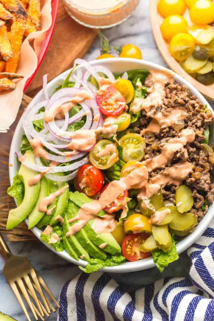 Low Carb Burger Bowls topped with special sauce with sweet potato fries