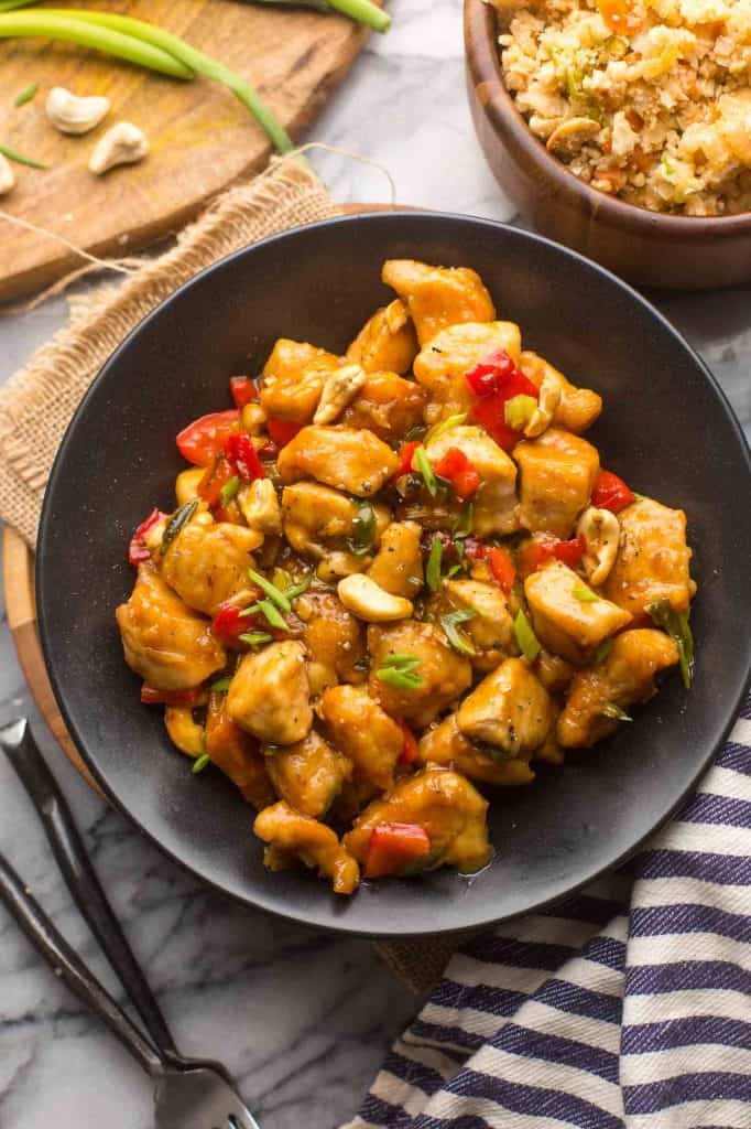 Paleo Cashew Chicken in a bowl with cauliflower fried rice on the side