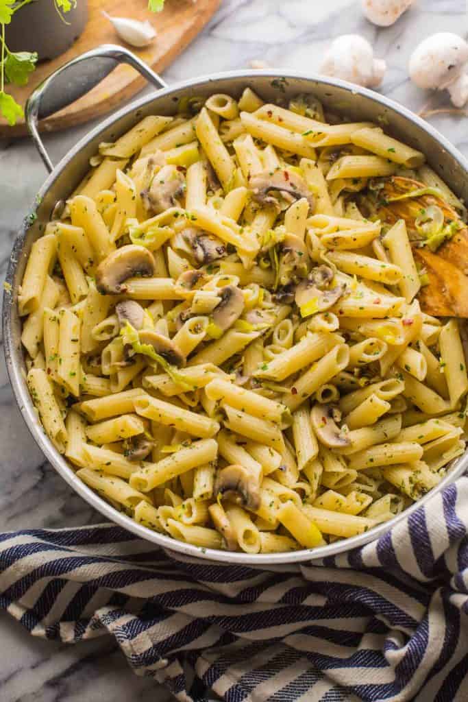 Leek and Mushroom Pasta in a skillet with a stripped blue tea towel