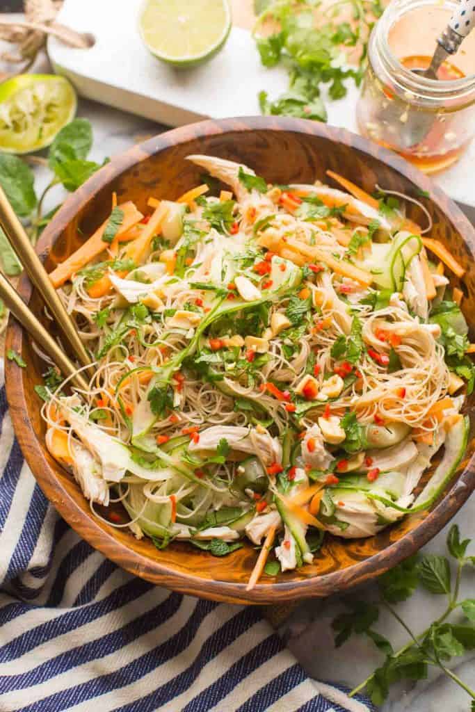 Vietnamese Chicken & Rice Noodle Salad in a salad bowl surrounded by fresh ingredients